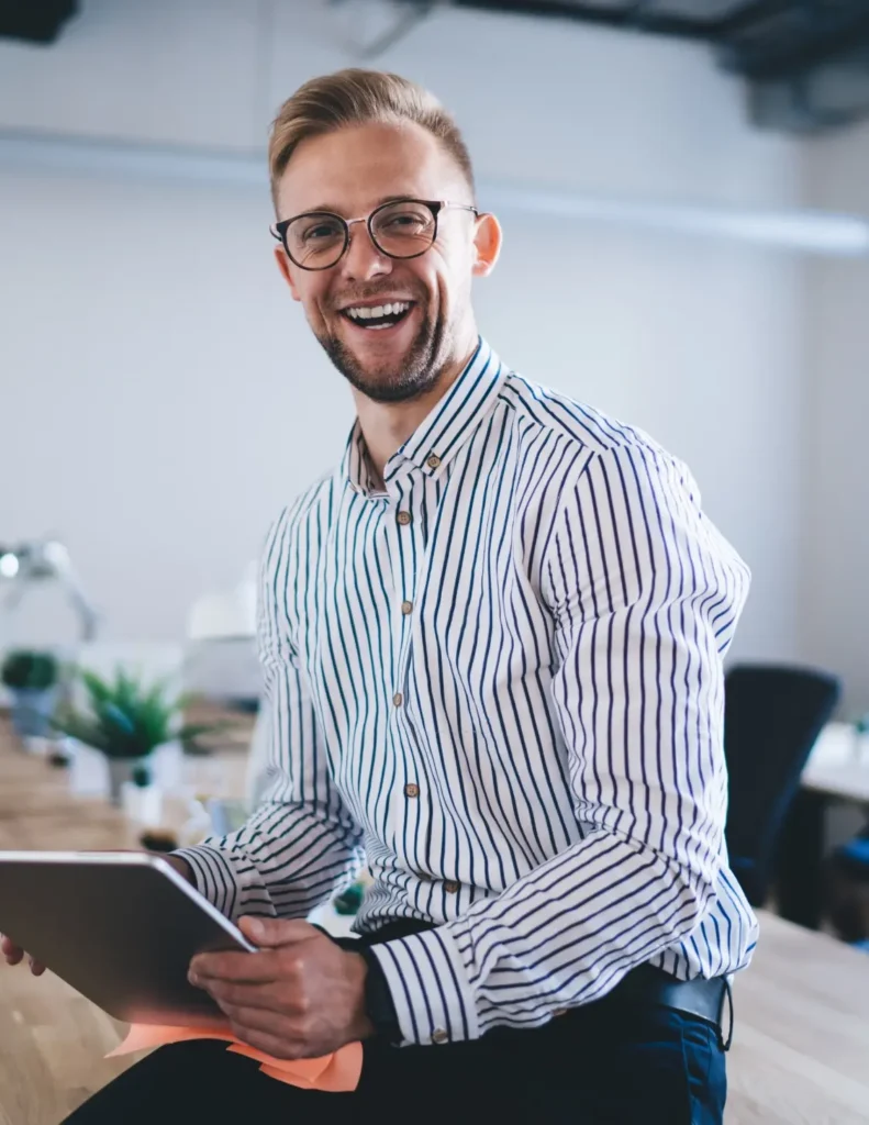 Entrepreneur souriant, tablette à la main, dans un espace de travail