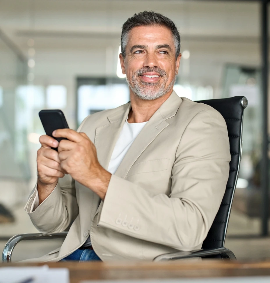 Dirigeant consultant son smartphone dans son bureau