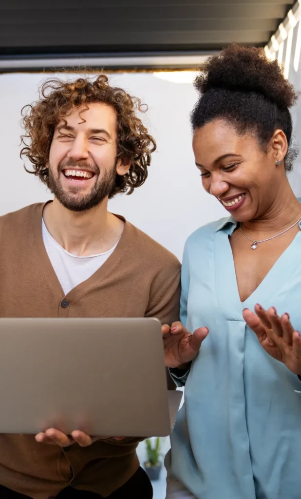 Deux associés souriants devant un ordinateur portable