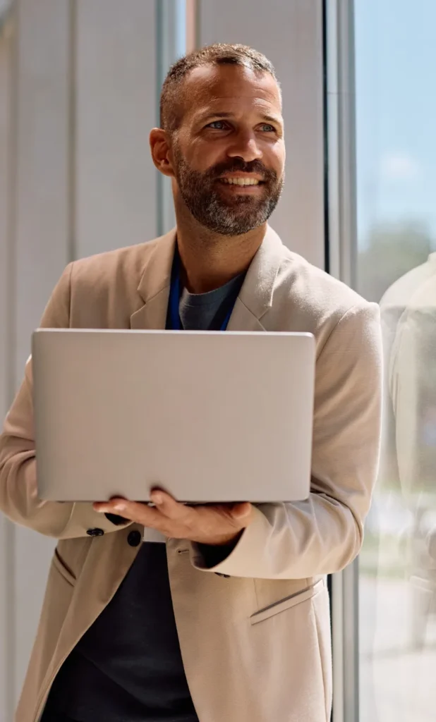 Entrepreneur souriant tenant un ordinateur portable