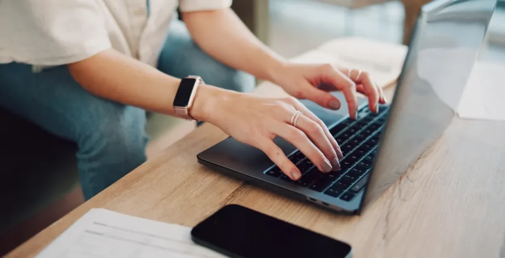 Mains sur le clavier d’un ordinateur portable